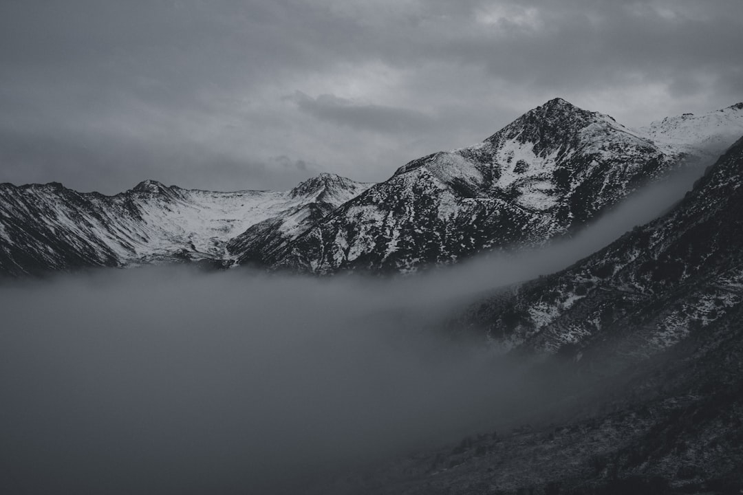 a black and white photo of snow covered mountains