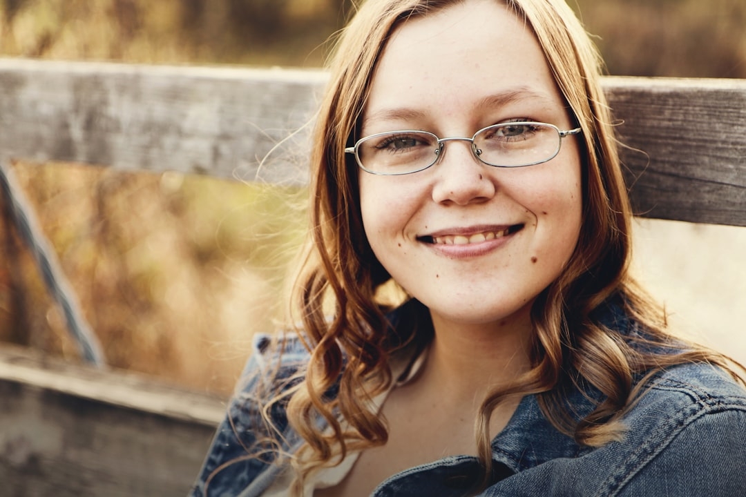 woman with eyeglasses sits on bench