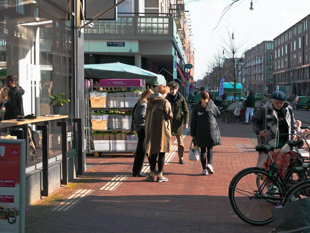 a group of people walking down a street next to tall buildings