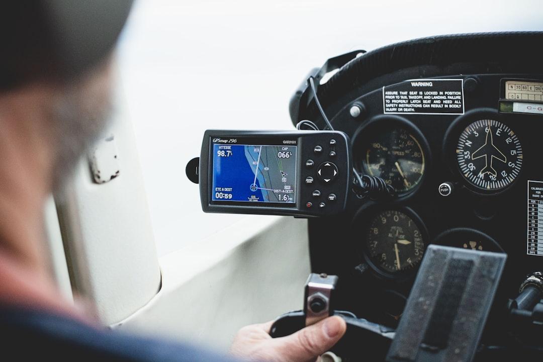 a man sitting in a cockpit of a plane looking at a gps