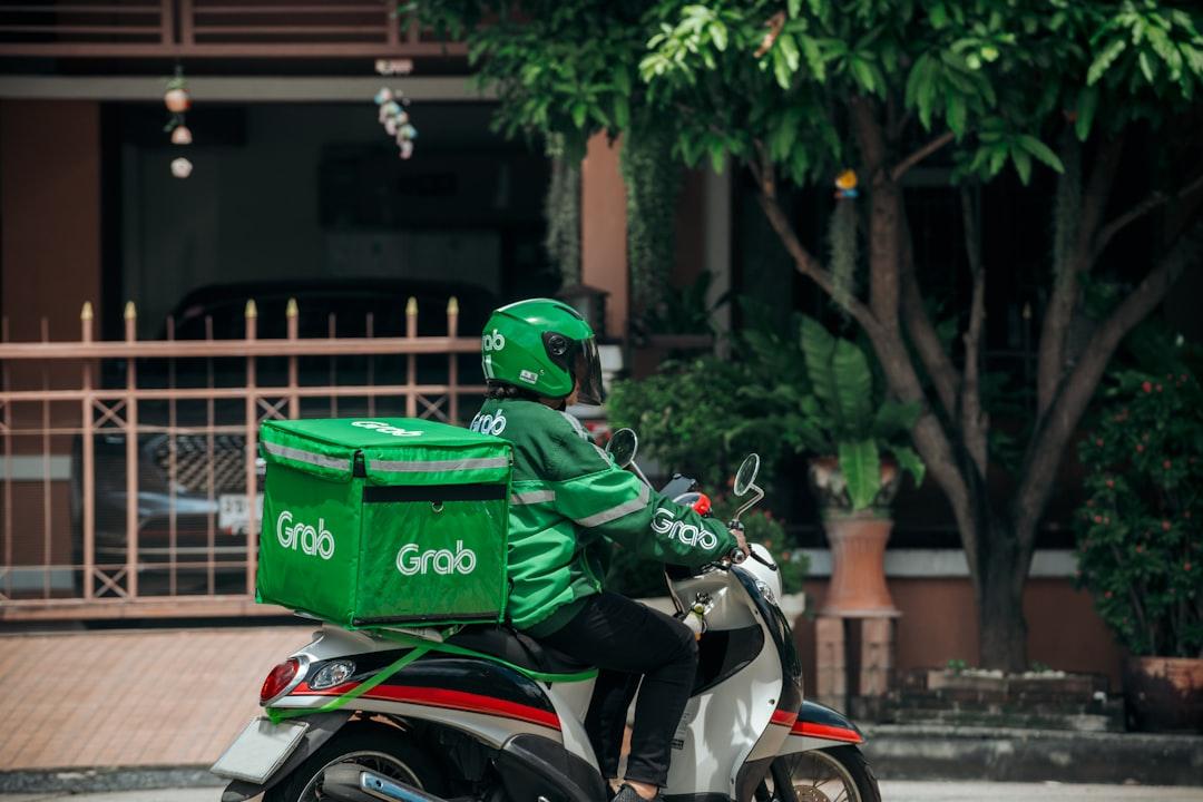 a person on a motorcycle with a green bag on the back