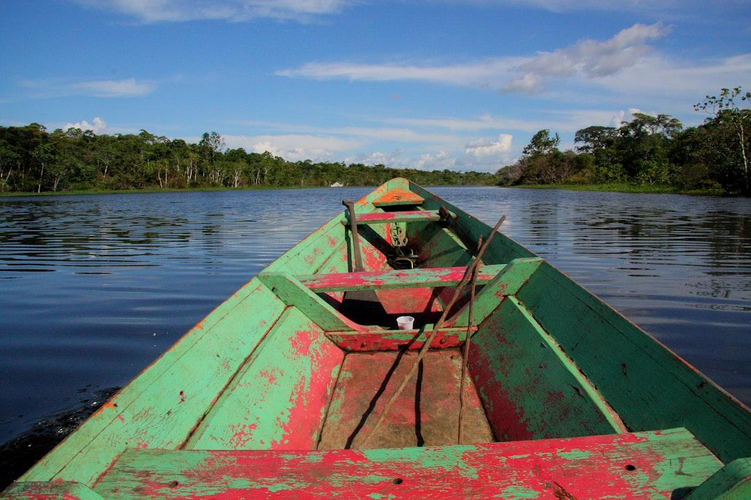 green and red canoe on lake during daytime