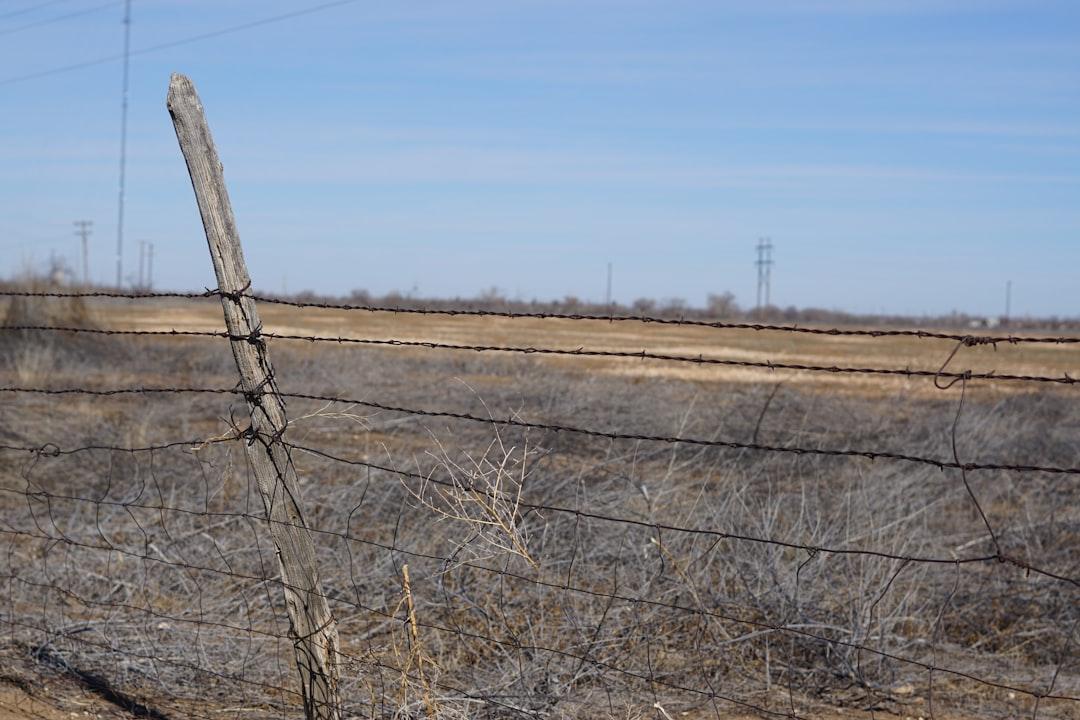 a barbed wire fence in the middle of a field